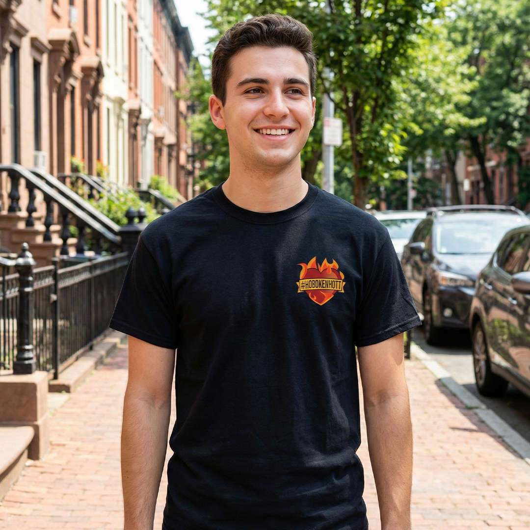 Man wearing a black t-shirt with a Hoboken Farms logo on a street