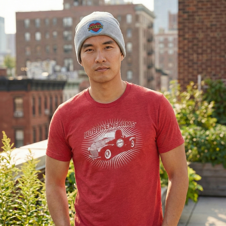 Man wearing a red t-shirt with a Hoboken Farms logo on and a gray beanie with a Hoboken Farms logo on it